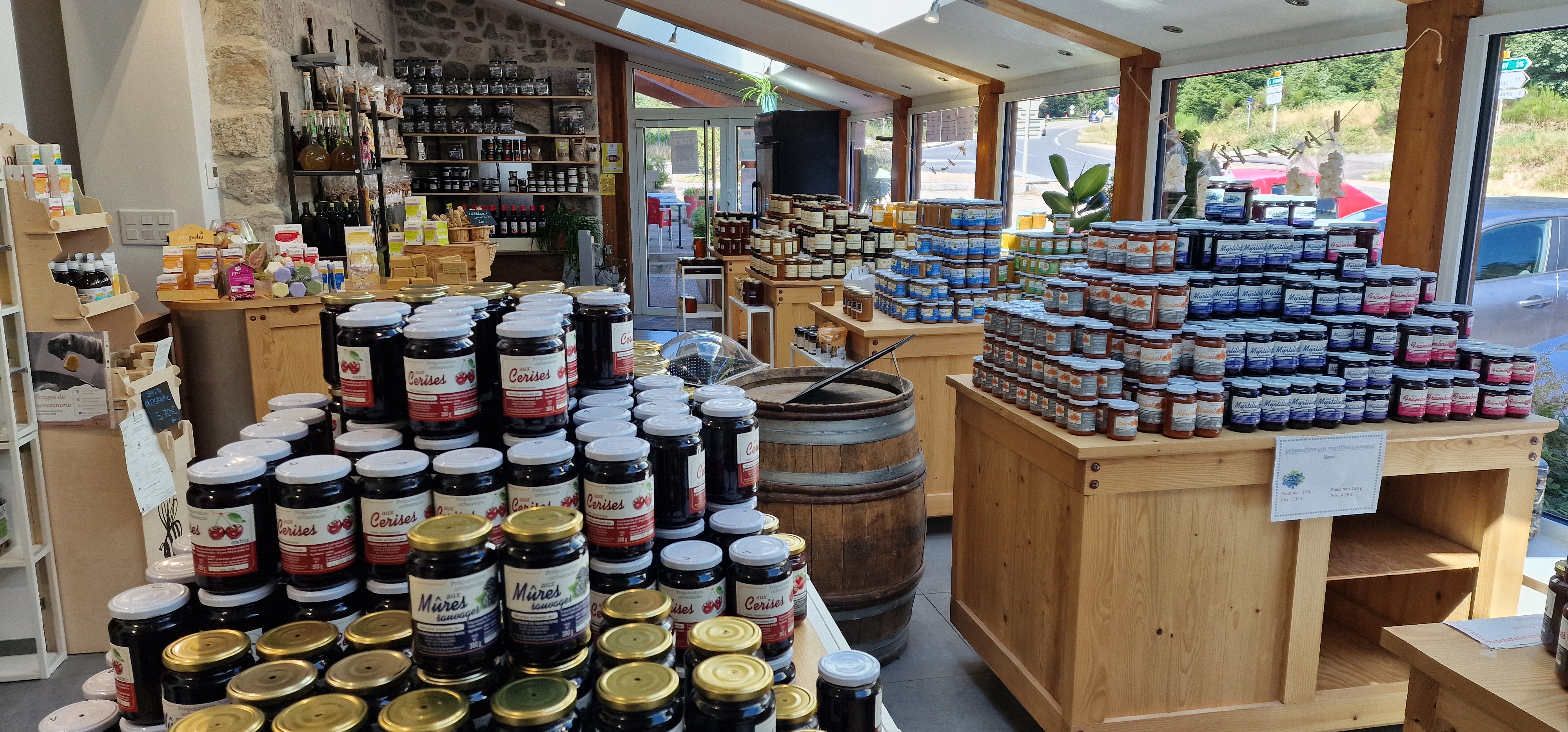 Vue horizontale de la boutique de l’Auberge du Grand Bois, sous la verrière, avec ses présentoirs de produits en bocaux. Photo du site officiel du prestataire.